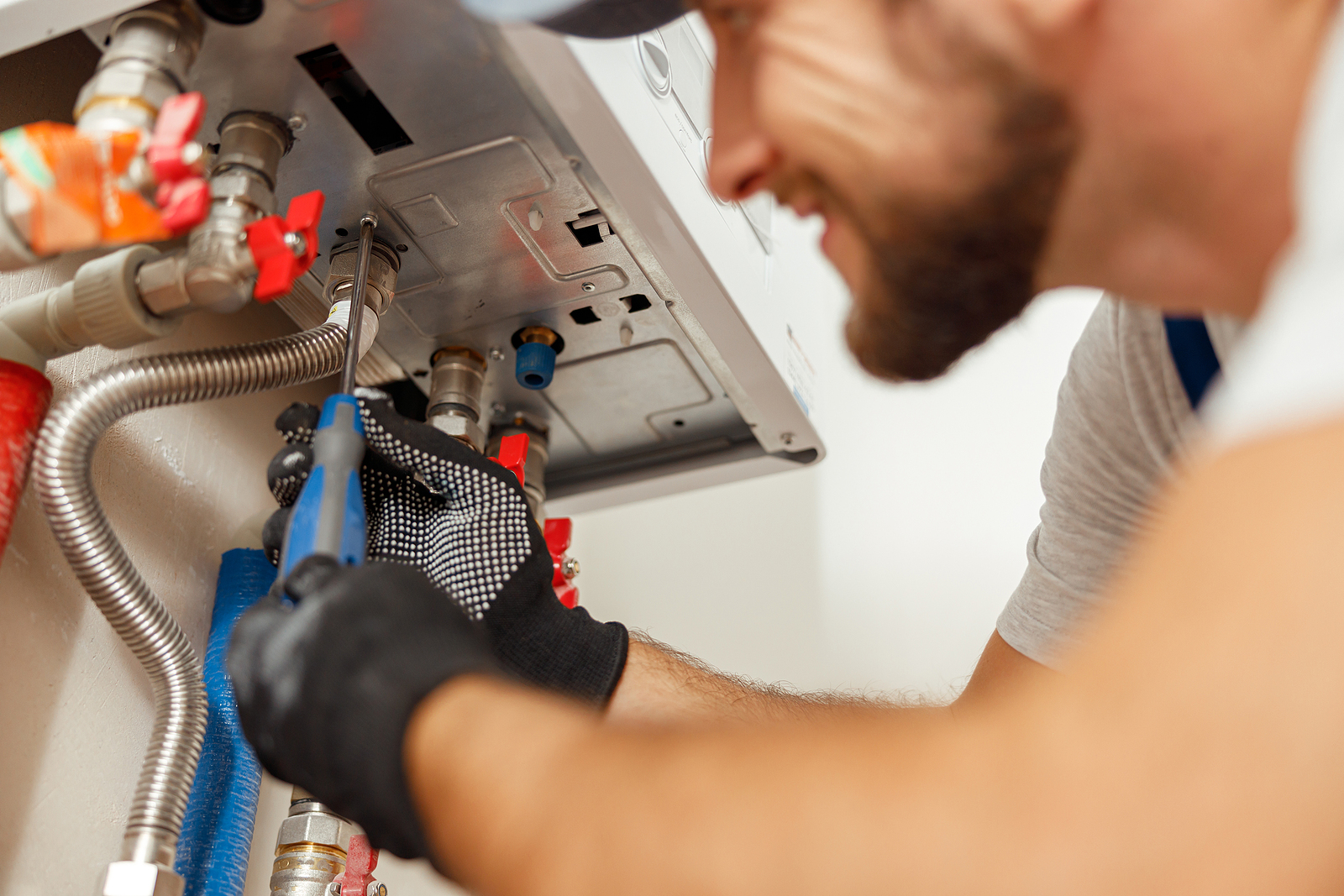 heating engineers in Surrey - Closeup of plumber using screwdriver