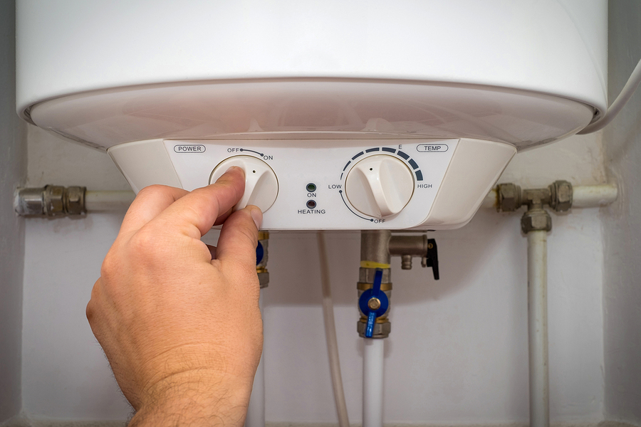 new boiler guildford - Man-Turns-On-The-Switch-On-Control-Panel-Of-Home-Electric-Water-Heater-Boiler